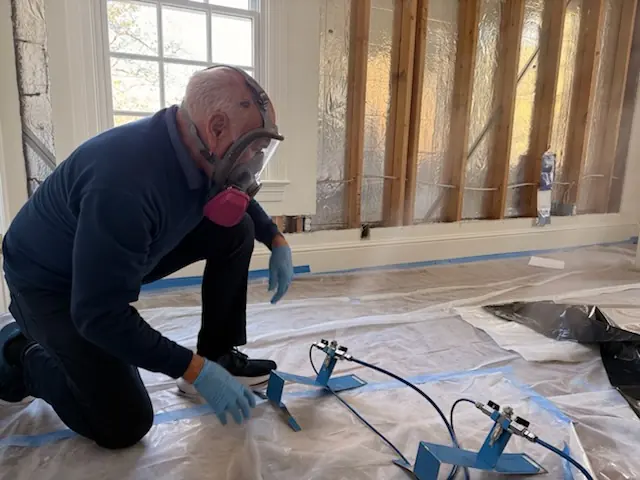 A restoration technician setting drying equipment in a San Mateo home stripped to the studs